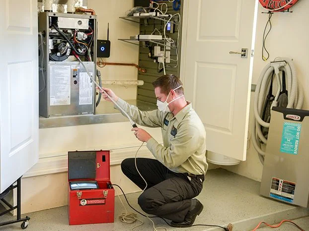 HVAC technician installing a WiFi thermostat in a Bakersfield home