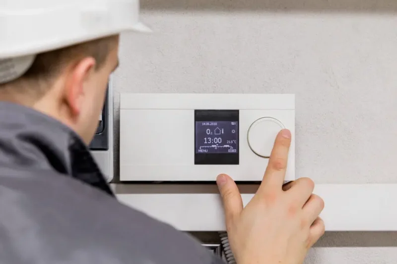 HVAC technician testing heating and cooling system performance