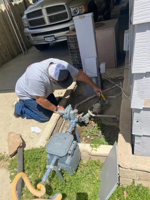 Technician performing emergency plumbing repair at a residential property