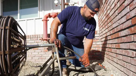 Technician performing plumbing installation or repair work