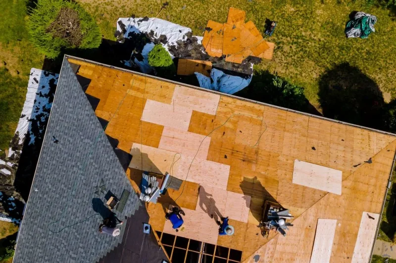 Technicians installing a new roof on a residential property